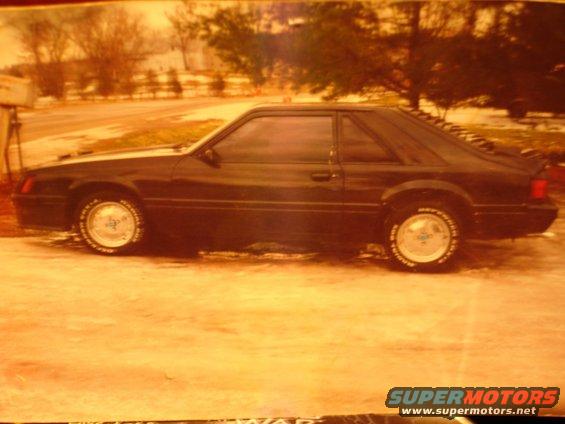Black coupe with louvers on the rear window, seen from the side
