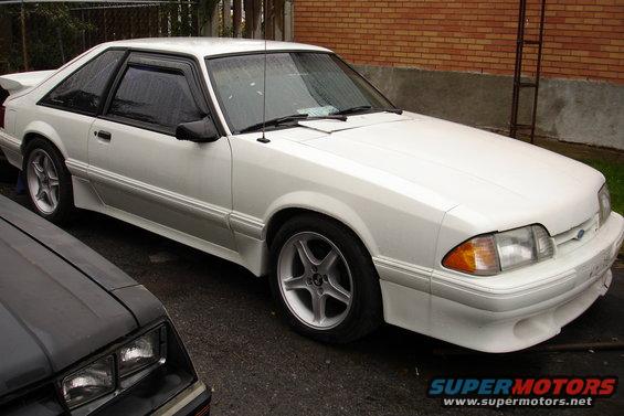 White coupe with aftermarket wheels, 3/4 front view