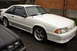 1981 Ford Mustang - White coupe with aftermarket wheels parked next to another vehicle.