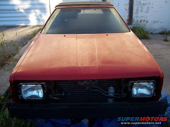 Red 1984 Toyota Celica front view with missing grille and headlights