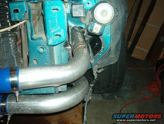 Engine bay with custom exhaust piping and turquoise paint