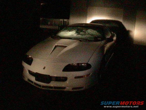 White 1996 Chevrolet Camaro parked at night, hood scoop visible
