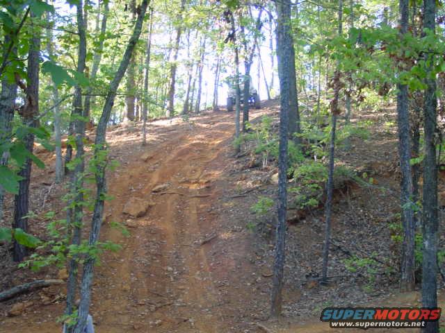 ATV on a dirt hill in a wooded area