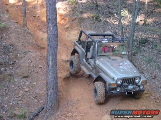 Jeep TJ going up a dirt trail, front winch visible