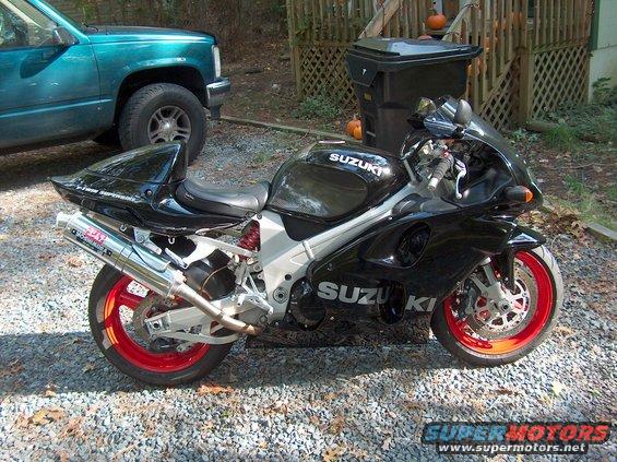 Black 2002 Suzuki TL1000R motorcycle with red wheels and Yoshimura exhaust parked on gravel