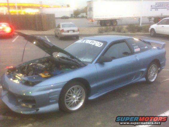1996 Ford Probe with hood open, showing engine bay. Aftermarket body kit and window banner visible