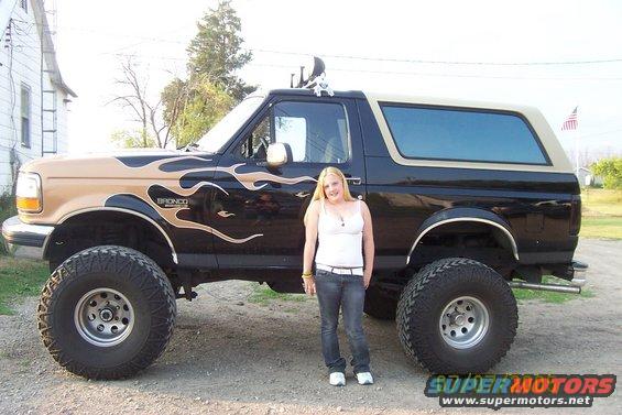 Black and tan lifted Ford Bronco with flame decals and large tires