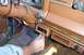 1985 Jeep Grand Wagoneer - A hand adjusts the 4WD shifter on the dashboard of a vintage Jeep, revealing its interior details and wood grain trim.