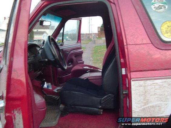 Interior of a red 1994 Ford Bronco showing the driver's seat and dashboard