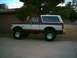 1988 Ford Bronco - Side view of a lifted maroon and white Ford Bronco from the late 1980s or early 1990s.