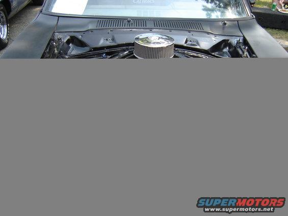 Black car engine bay with chrome air cleaner and visible engine components