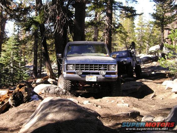 Front view of a 1986 Ford Bronco II on a rocky trail, with another SUV behind it