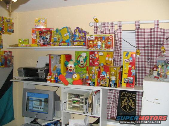 Shelves filled with Simpsons toys, including action figures and boxes. A Fiero logo is visible on a black banner