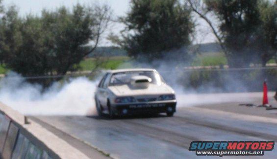 White Fox body Mustang doing a burnout on a drag strip, smoke billowing
