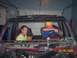 1994 Ford Bronco - Two men are inside a vehicle that appears to be undergoing repairs or a teardown, with a can of Coors Light on the dashboard.
