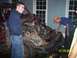 1994 Ford Bronco - A heavily damaged red SUV sits with its front end destroyed, as two men inspect the engine compartment.