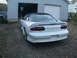 1996 Chevrolet Camaro - The rear of a white 1996 Chevrolet Camaro is visible, parked on a gravel driveway in front of an open garage.