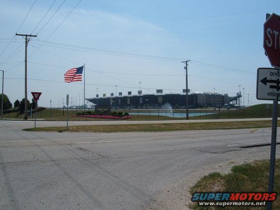 Stadium with American flag flying, water feature, and traffic signs
