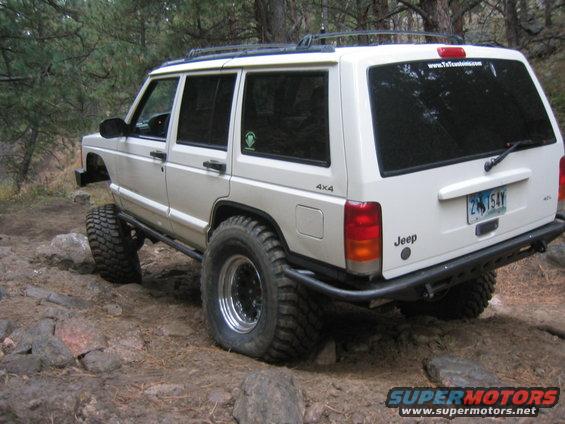 White 1997 Jeep Cherokee with off-road tires on a rocky trail
