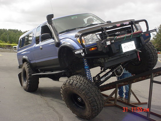 Blue Toyota Tacoma with snorkel and off-road bumper on ramp