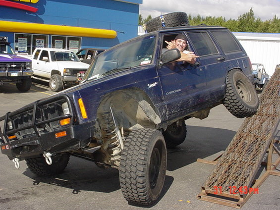 Blue Jeep Cherokee XJ on ramp with driver giving the finger