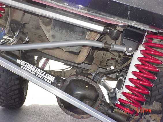 Undercarriage with red coilover shocks and Trail Toyz sticker. No year visible