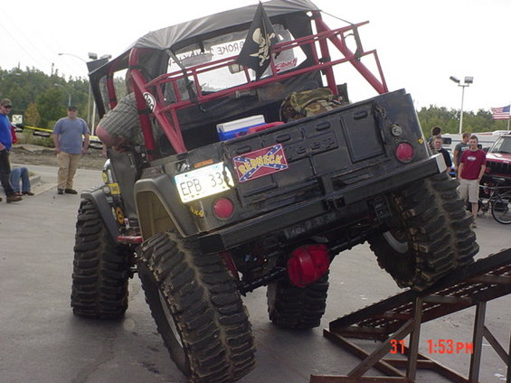 Jeep CJ with big tires on ramps, pirate flag on back