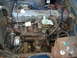1973 Jeep CJ5 - Engine bay of a blue vehicle, showing the engine, carburetor, and alternator.