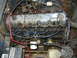 1973 Jeep CJ5 - Close-up view of a V6 engine bay, showing the distributor, spark plug wires, and battery.
