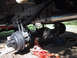 1990 Ford Bronco - Vehicle's rear axle and suspension components are visible, supported by hydraulic jacks.