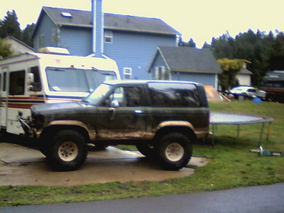 1987 Ford Bronco II parked next to an RV