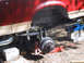 1990 Ford Bronco - The rear suspension of a 1990 Ford Bronco, showing leaf springs and brake drum, is supported by jacks.