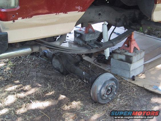 Rear axle assembly removed from a vehicle, supported by jack stands and concrete blocks