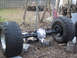 1990 Ford Bronco - A rear axle assembly with large tires is shown outdoors, supported by blocks.