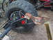 1990 Ford Bronco - A close-up view shows a large tire and part of a vehicle's suspension system, including red brake calipers.