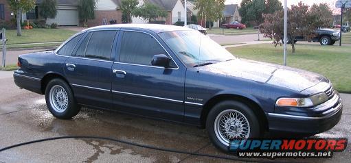 Dark blue 1994 Ford Crown Victoria sedan parked on wet concrete driveway