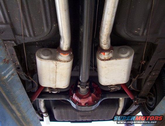 1969 Ford Mustang undercarriage showing dual exhaust mufflers, driveshaft, and red differential
