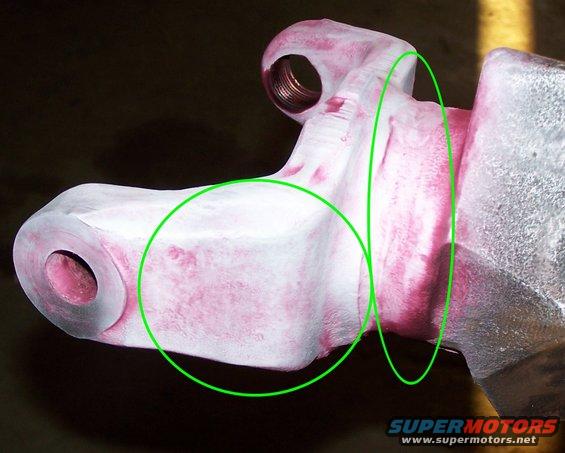 Metal suspension component with pink dye penetrant residue visible in green circles