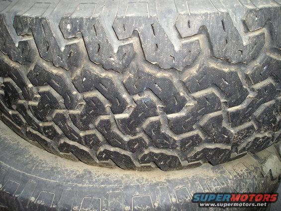 Close-up of a tire tread with visible Supermotors.net logo