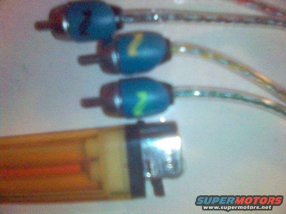 Three blue spark plug wire boots with green '7' markings and a yellow lighter