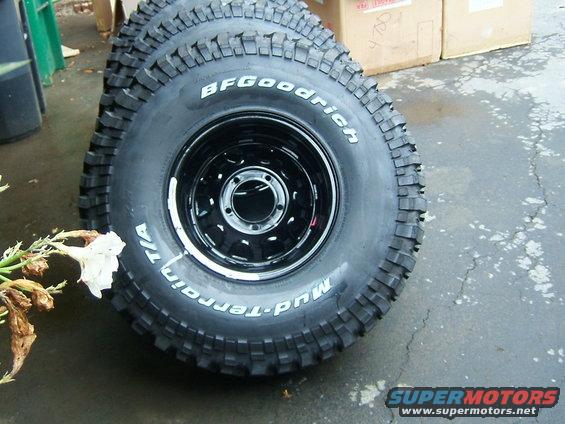 Three BFGoodrich Mud-Terrain T/A tires with black rims stacked, one tire in focus