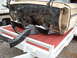 1964 Ford Galaxie - The front frame and firewall of a vehicle are shown disassembled and loaded onto a trailer.