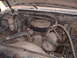 1984 Ford Bronco - The engine bay of a white Ford truck from the 1980s shows a V8 engine with various hoses and components.