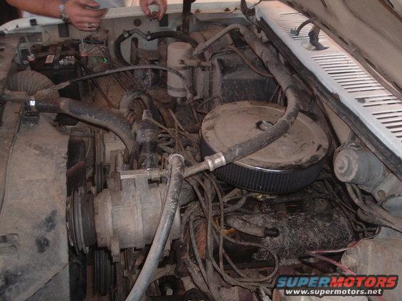 Engine bay with air filter and hoses visible