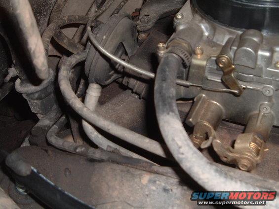 Close-up of engine carburetor with hoses and wiring