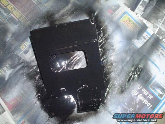 black painted metal part on newspaper