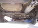 1993 Ford Probe - Person working on the exhaust system of a car raised on ramps.