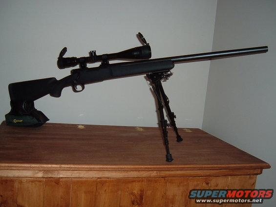 Sniper rifle with scope and bipod on a wooden surface