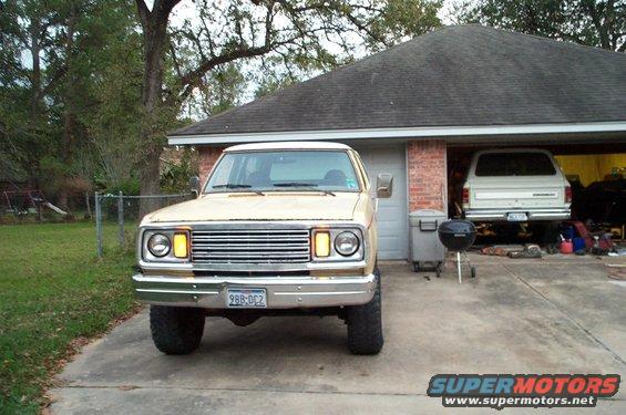 Tan Dodge Ramcharger parked in driveway, another SUV in garage. License plate 988-DC2