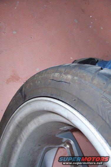 close-up of a worn tire with a crack on the sidewall